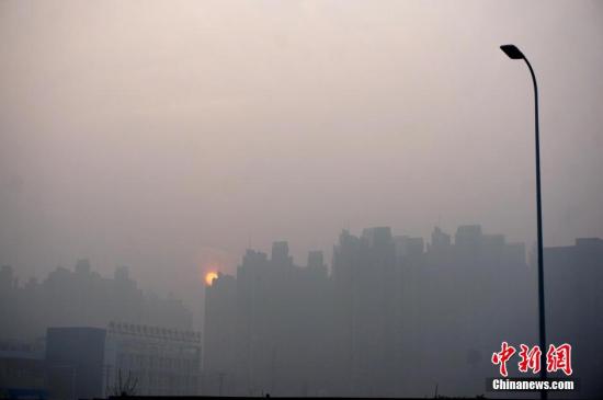 资料图 1月3日，河南郑州雾霾笼罩着的高楼大厦。