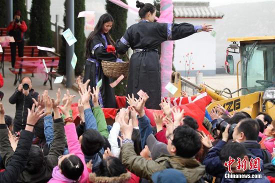 3月5日，三八国际妇女节前夕，河南济源黄河三峡景区举办“3.7女生节”首日，为女士发红包，为吸引人气，现场两名身穿古装的美女挎荆篮装着上百万的外币红包登上铲车，向现场女士撒洋钱，也有不少男士也纷纷加入抢红包行列。