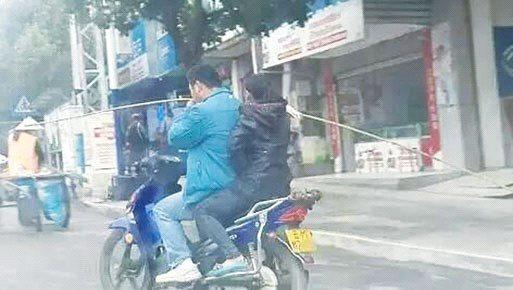 图为丈夫骑摩托车载妻子