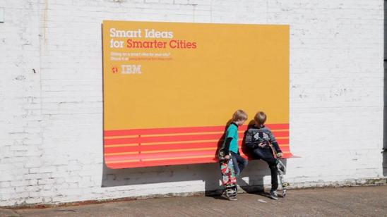 为激发人们分享创意、共建「智慧城市」，IBM联手法国奥美广告以「People For Smarter Cities」为主题，创建了一系列别具一格的户外广告牌 。它们既是广告牌，也是遮雨篷、也是公共长凳、也是便利斜坡，企业在宣传自身的同时，亦为公共事业尽出了一分力，为人们带来更便携、更理想的城市环境。