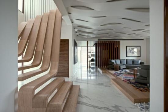 作为印度孟买SDM公寓项目的一部分 ，Arquitectura en Movimento Workshop在其间带来了这一设计极其精美的木制楼梯。它被建筑师设想为公寓内的功能性雕塑，因此有意似撇开了「扶手」这个安全因素，上下层楼梯板仿佛一体成型的流线型衔接在一块， 创建出流动和运动的感觉，并在巨大的落地窗下将整体营造成一个自然采光、通风的舒适空间。