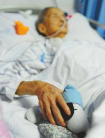 12日，李河清老人正在病床上休息，手里握着家人送给她的玩偶。