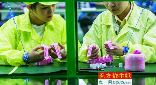 4月12日，中山某品牌儿童智能手表生产车间，两名生产线上的工人正在检查产品。南都记者谭庆驹 摄