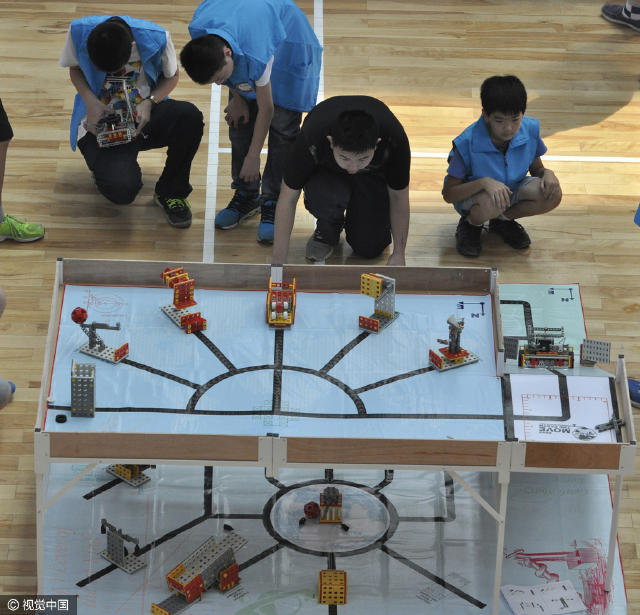 2016年4月16日，在南宁市中小学生机器人比赛开始前，孩子们在观看机器人抢气球表演。 图片来源：视觉中国