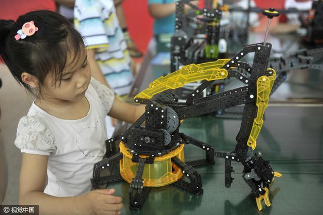 2016年4月16日，在南宁市中小学生机器人比赛开始前，孩子们在观看机器人抢气球表演。 图片来源：视觉中国