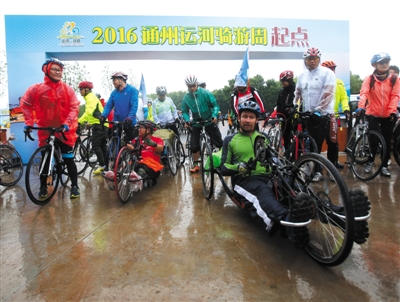 昨日，通州漕运码头，“2016通州运河骑游周”活动举办，两名手摇车手和其开奖直播骑游爱好者一起出发，其中穿红色衣服的车手为残疾人。