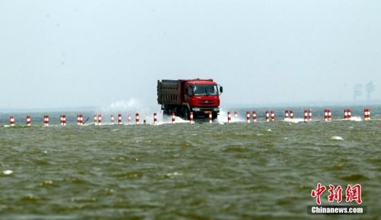 连日来，江西遭遇持续强降雨，中国最大淡水湖鄱阳湖水位连续上涨，被网友誉为“最美水上公路”的永吴公路大湖池段已被淹没。过往车辆行驶在其中，犹如“水上漂”。钟欣 摄