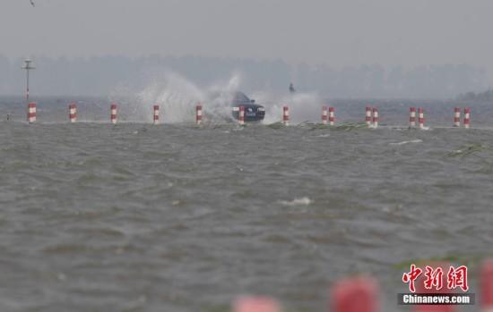 连日来，江西遭遇持续强降雨，中国最大淡水湖鄱阳湖水位连续上涨，被网友誉为“最美水上公路”的永吴公路大湖池段已被淹没。过往车辆行驶在其中，犹如“水上漂”。钟欣 摄