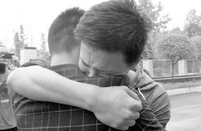 分离了13年的陈良伟兄弟俩拥抱在一起。