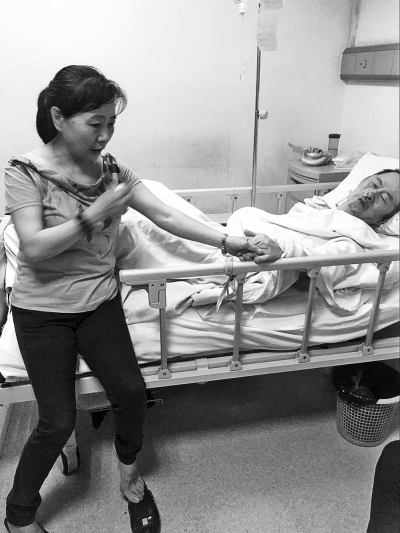 唐孝琴在医院照顾老伴，闲下来时总会拉着丈夫的手，不松开