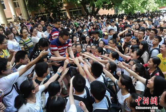 6月6日，重庆育才中学老师为即将参加高考的学生发高考红包，寓意考试顺利。当日下午，正是考生们看考场的时间，重庆育才中学高三7班和8班的班主任为学生们准备了每个6元的高考红包，以此为考生加油，希望每个考生都能考出好成绩。 周毅 摄