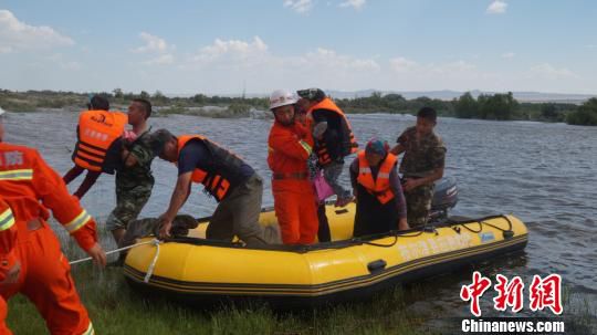 图为布尔津县消防人员用冲锋舟帮助牧民转移。 徐明辉 摄