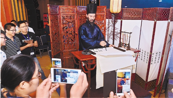 6月13日，在峰会机器人展示区，宁波市智能制造产业研究院研发的“王阳明写字机器人”在表演书法。 黄曙林 吴元峰 谢敏军 摄