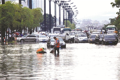 昨日，晋江市市政园林局工作人员在积水路段排水。