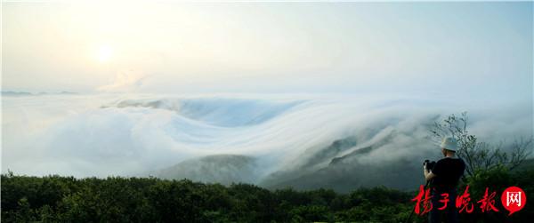 扬子晚报网6月21日讯 2016年6月21日，连云港市出现犹如仙境的平流雾景观，该市花果山在云雾中若隐若现。