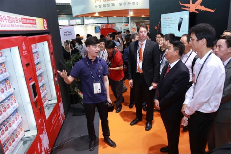 图4工信部总工程师张峰(右二)听取国际免卡贩售机的介绍