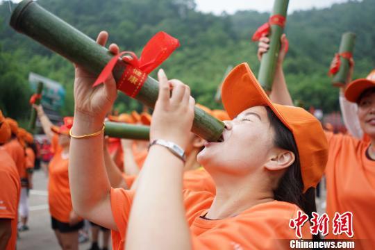 数千游客手举竹筒喝啤酒，短短数十秒就喝光，场面壮观。 贾亲亲 摄