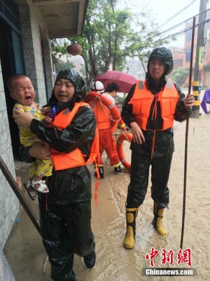 7月9日13时45分，今年第1号台风“尼伯特”在福建石狮沿海登陆。受台风影响，强降雨侵袭福州，多地内涝严重。图为消防官兵在福州闽侯县救援受困人员。 中新社记者 陈帆 摄