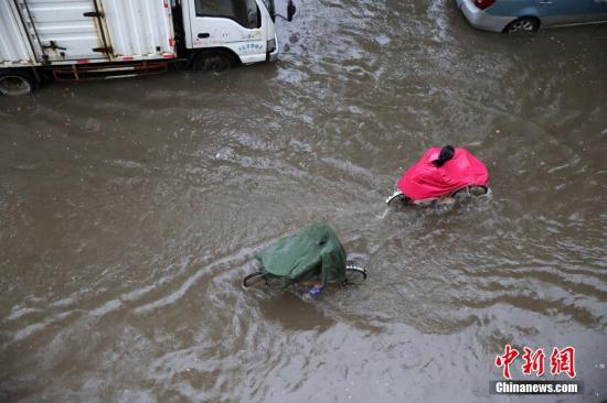 7月19日凌晨，一场暴雨突降河北省邯郸市，市区内出现“看海模式”，使早晨上班的市民艰难出行。中新社发 郝群英 摄 图片来源：CNSPHOTO