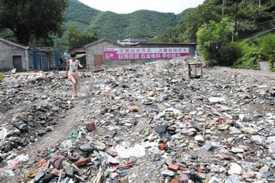 昨日，门头沟清水涧沟下游，因7月20日大雨，顺河道从山坡上冲下的大量生活垃圾，堆满住户门口。新京报记者 贺顿 摄