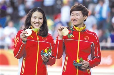 宫金杰（左）、钟天使展示奥运金牌。