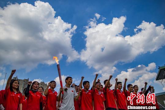 广州亚运会田径百米冠军劳义手举“火炬”与“闪电”骑行队志愿者为里约奥运会中国田径队助威加油。 泱波 摄