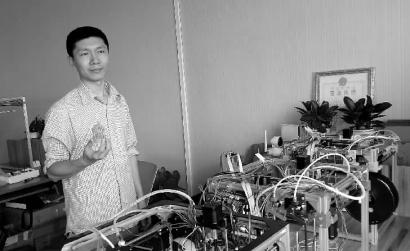 王海龙和他独立研制的3D打印机 新文化记者 杨威 摄